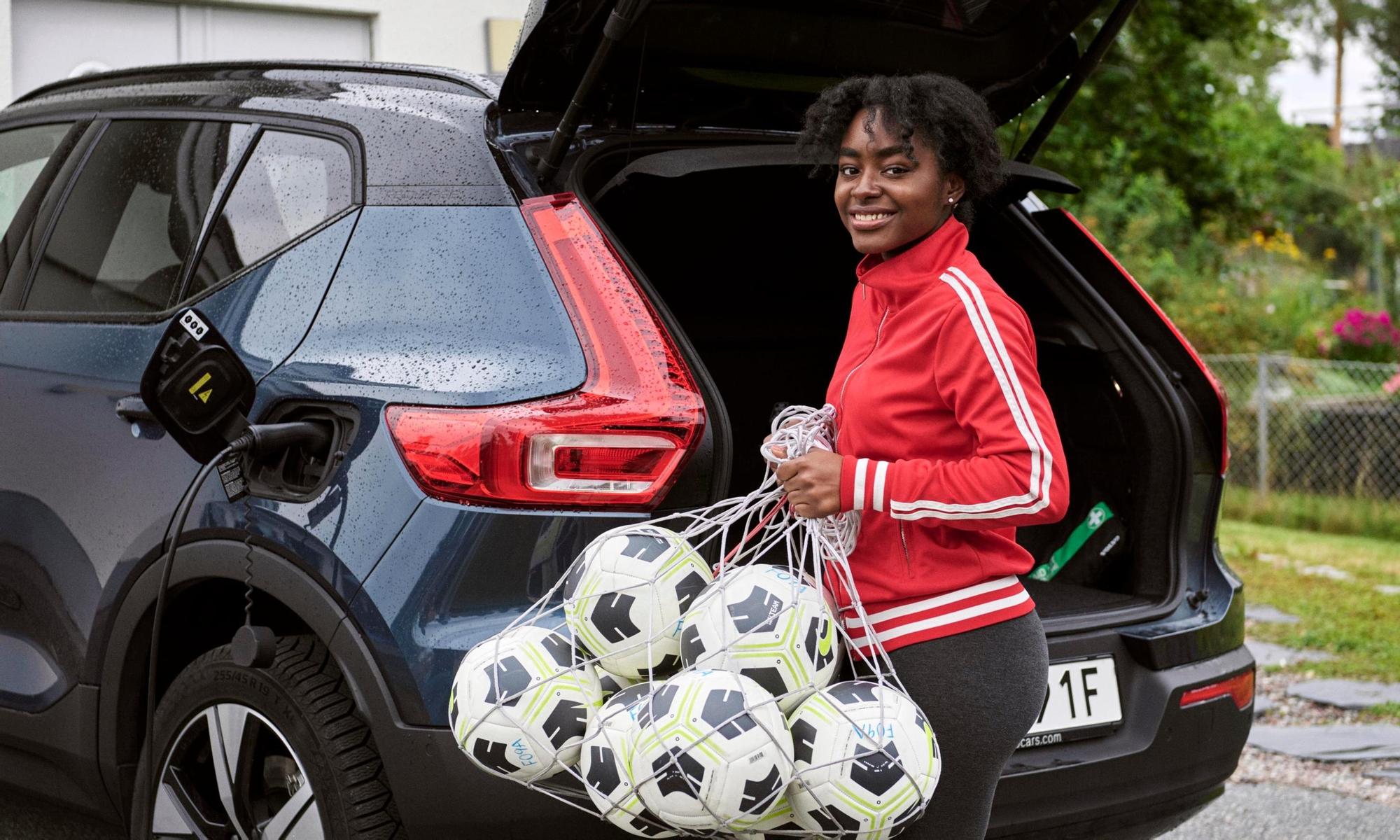 Female soccer coach packing soccer balls in the car