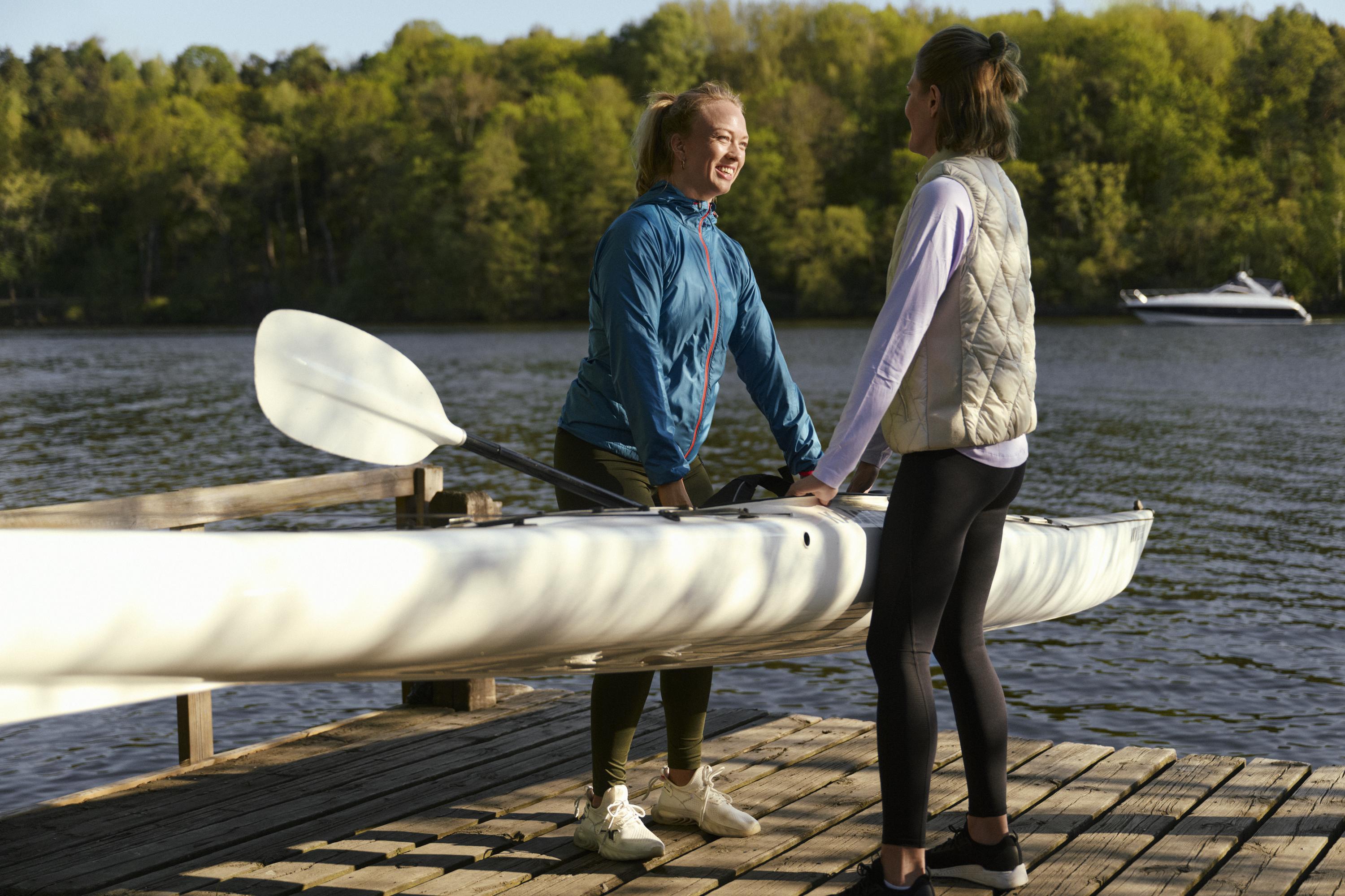 Två kvinnor bär en kajak